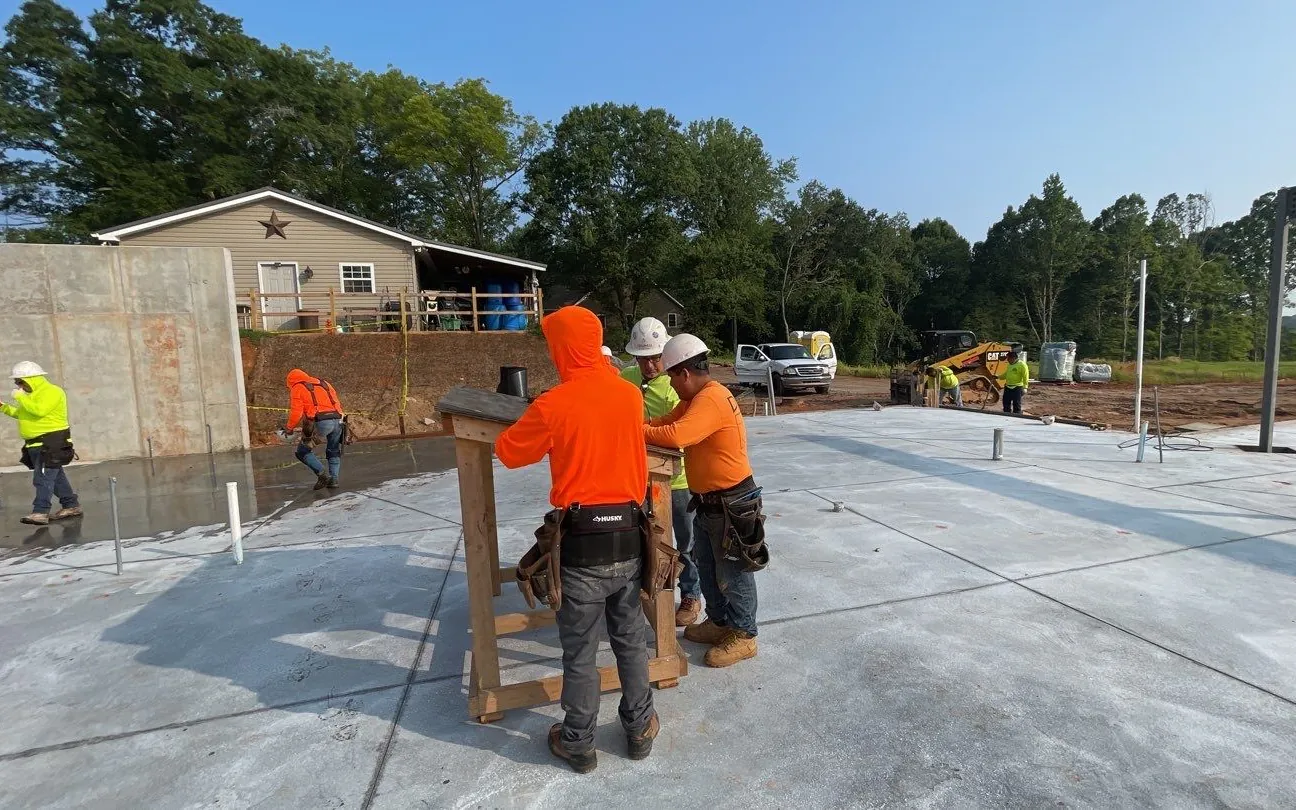 DATM crew standing a framed wall on a fresh slab